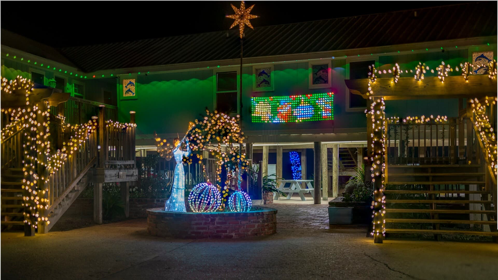 A festive courtyard illuminated with colorful holiday lights and decorations.
