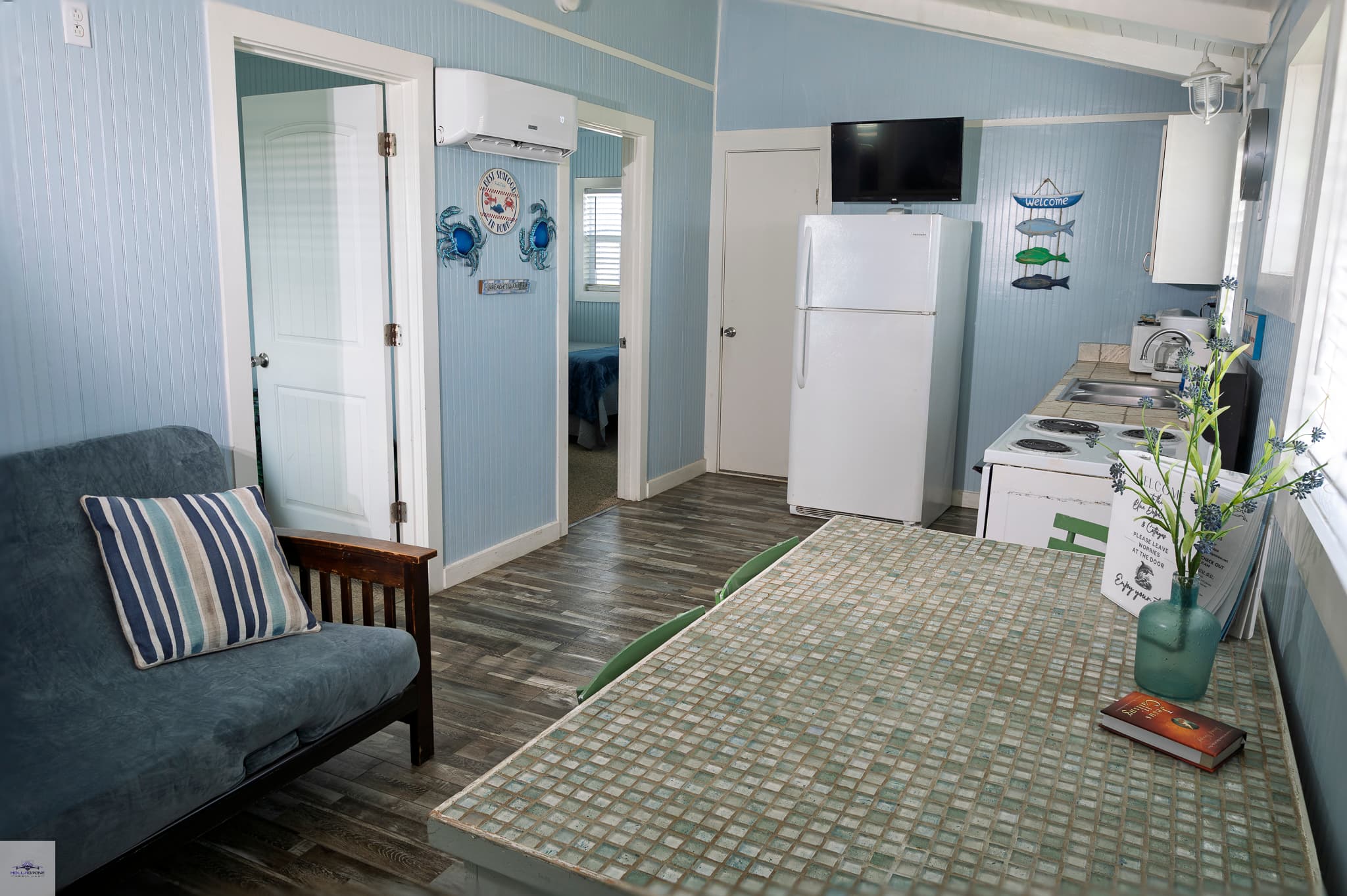 A kitchen with a dining table, sofa bed, and 2 doorways opening to additional rooms
